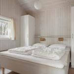 Schlafzimmer mit Bett, Fenster und Kleiderschränken an den Wänden.