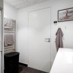Wasch- und Trocknerbereich mit Badewanne und Handtuchhalter