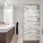 Badezimmer mit Dusche, Waschbecken und Spiegel