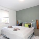 Schlafzimmer mit Bett, Fenster und grüner Wand