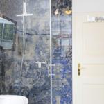 Bad mit Dusche, blauem Marmor und weißem Waschtisch