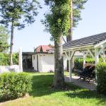 Hinterhof mit Pavillon, Gartenmöbeln, Bäumen und Rasenfläche.