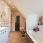 Badezimmer mit Badewanne, Dusche und Toilette unter Dachschräge