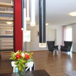 Haus mit offener Küche, Wohnbereich und Treppe zur oberen Etage.