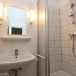 Badezimmer mit Dusche, Waschbecken und Spiegel