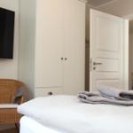 Schlafzimmer mit Bett, Kleiderschrank, TV und Stuhl.