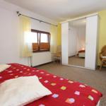 Schlafzimmer mit Bett, Kleiderschrank und Stuhl