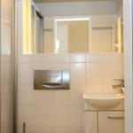 Badezimmer mit Dusche, Waschbecken und Spiegel