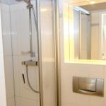 Dusche mit Duschbrause und Spiegel mit Beleuchtung