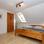 Schlafzimmer mit Holzbett, Dachschiebefenster und Nachttisch