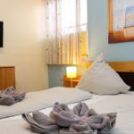 Schlafzimmer mit Bett, Fernseher und Fenster mit Blick auf Strand.