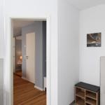 Flur mit Holzboden, Wandregal und Bildern an der Wand