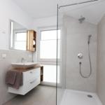 Badezimmer mit Dusche, Waschbecken und Spiegel