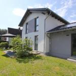 Moderne Villa mit Garten, Sonnenschutz und Terrasse. Haus mit Fenstern und Dach.