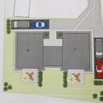 Plan zeigt zwei Gebäude mit Parkplätzen und zwei Gartenbereichen mit Sonnenschirmen.