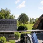 Terrasse mit Blick auf grünen Garten und traditionelle Häuser mit Dach