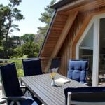 Terrasse mit Tisch und Stühlen, Blick auf Wald und Häuser.