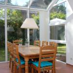 Esszimmer mit Holztisch, Stühlen und Blick auf Garten