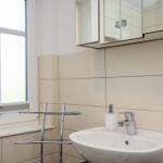 Badezimmer mit Waschbecken, Spiegelschrank und Fenster.