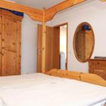 Schlafzimmer mit Holzbett, Kleiderschrank und Schminktisch