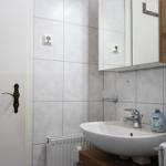 Badezimmer mit Waschbecken, Spiegelschrank und Handtuchhalter.