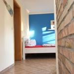 Ein Raum mit einem Bett, blauer Wand und Backsteinwand