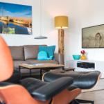 Ein Wohnzimmer mit Sofa, Couchtisch und Fernseher an der Wand.