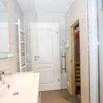 Badezimmer mit Dusche, Waschbecken und Sauna