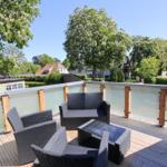 Terrasse mit Gartenmöbeln und Blick auf begrünte Umgebung.