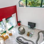 Wohnraum mit Glasboden, Sofa, Fernseher und Blick auf Balkon.