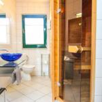 Badezimmer mit Sauna, blauem Waschbecken und Toilette