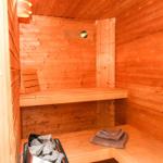 Sauna mit Holzwand, Sitzbank und Handtuch