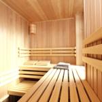 Sauna mit Holzbänken und einer Deckenleuchte.