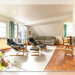 Wohnzimmer mit zwei schwarzen Sesseln, Sofa und Terrassentür.