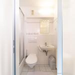 Badezimmer mit Dusche, Toilette und Waschbecken.