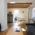 Wohnzimmer mit Sofa, Couchtisch und Blick in Essbereich mit Tisch und Stühlen.