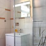 Badezimmer mit Dusche, Waschbecken und Spiegel