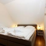 Schlafzimmer mit Bett, Nachttisch und Fenster