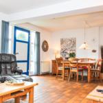 Wohn- und Essbereich mit Holzmöbeln, Sitzgelegenheiten und Fenster zur Außenseite.