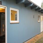 Sauna mit Holzinnenraum und blauem Außenbereich mit Fenstern und Tür.