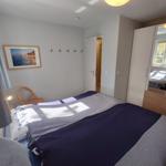 Schlafzimmer mit Bett, Kleiderkabine und Wandbild