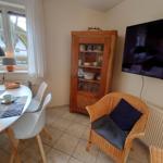 Esszimmer mit Tisch, Stühlen, TV und Holzschrank.