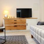 Wohnzimmer mit Sofa, TV-Boden und Beleuchtung.