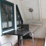Terrasse mit Tisch, zwei Stühlen und Wäscheständer an der Wand.