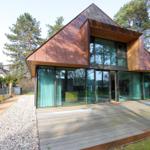 Moderne Holzhütte mit großem Glasbereich und Terrasse im Wald