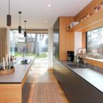 Moderne Küche mit Holzakzenten und großem Fensterblick auf den Garten