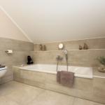 Bad mit Dusche, Badewanne und Toilette. Holzoptik und Seetiere dekorieren den Raum.