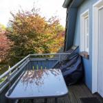 Terrasse mit Tisch, Gartenblick und blauem Haus