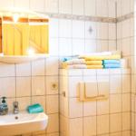 Badezimmer mit Waschbecken, Spiegelschrank und gefalteten Handtüchern.