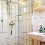 Badezimmer mit Dusche, Waschbecken und Spiegel